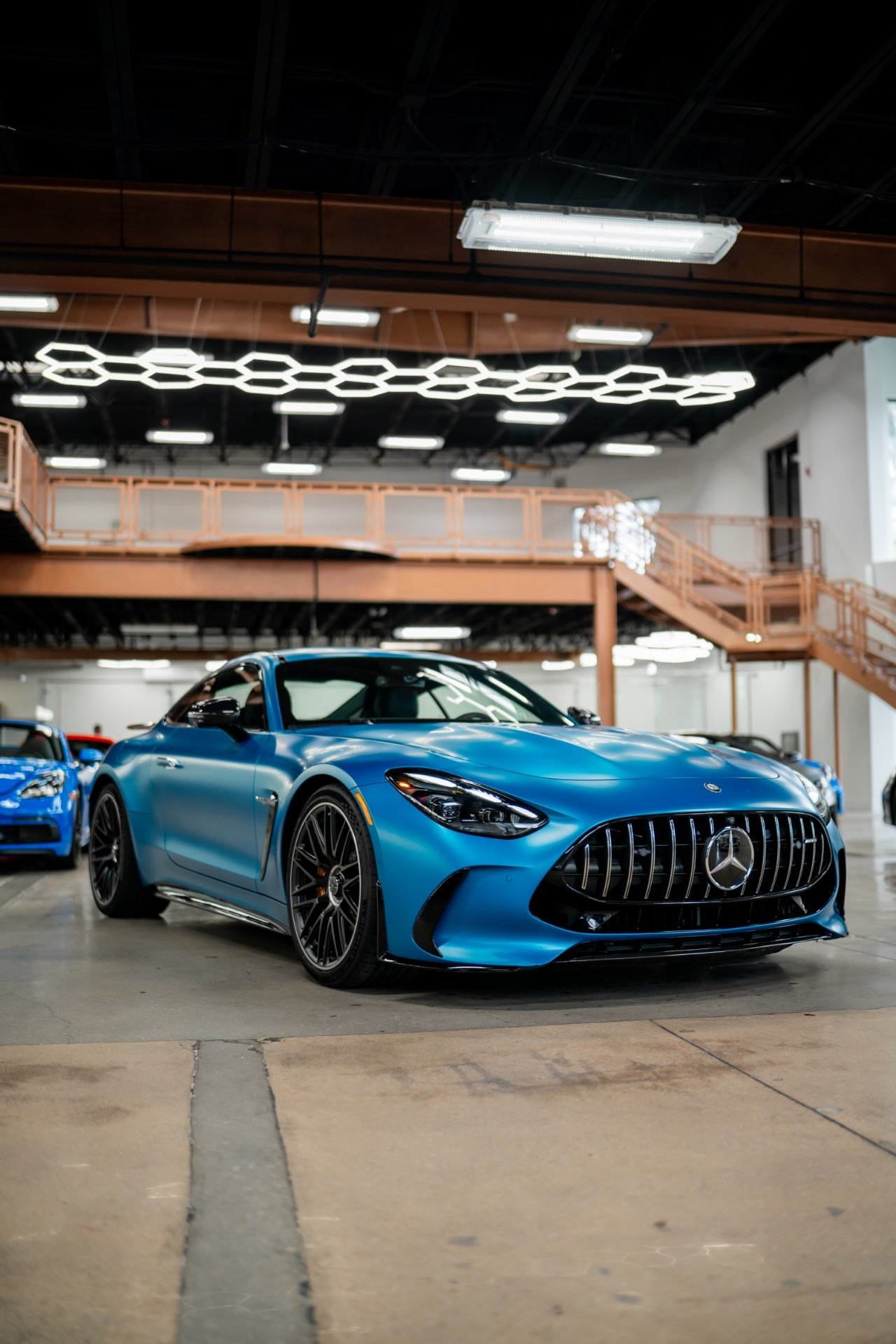 Blue Mercedes-AMG GT in showroom under hex lighting