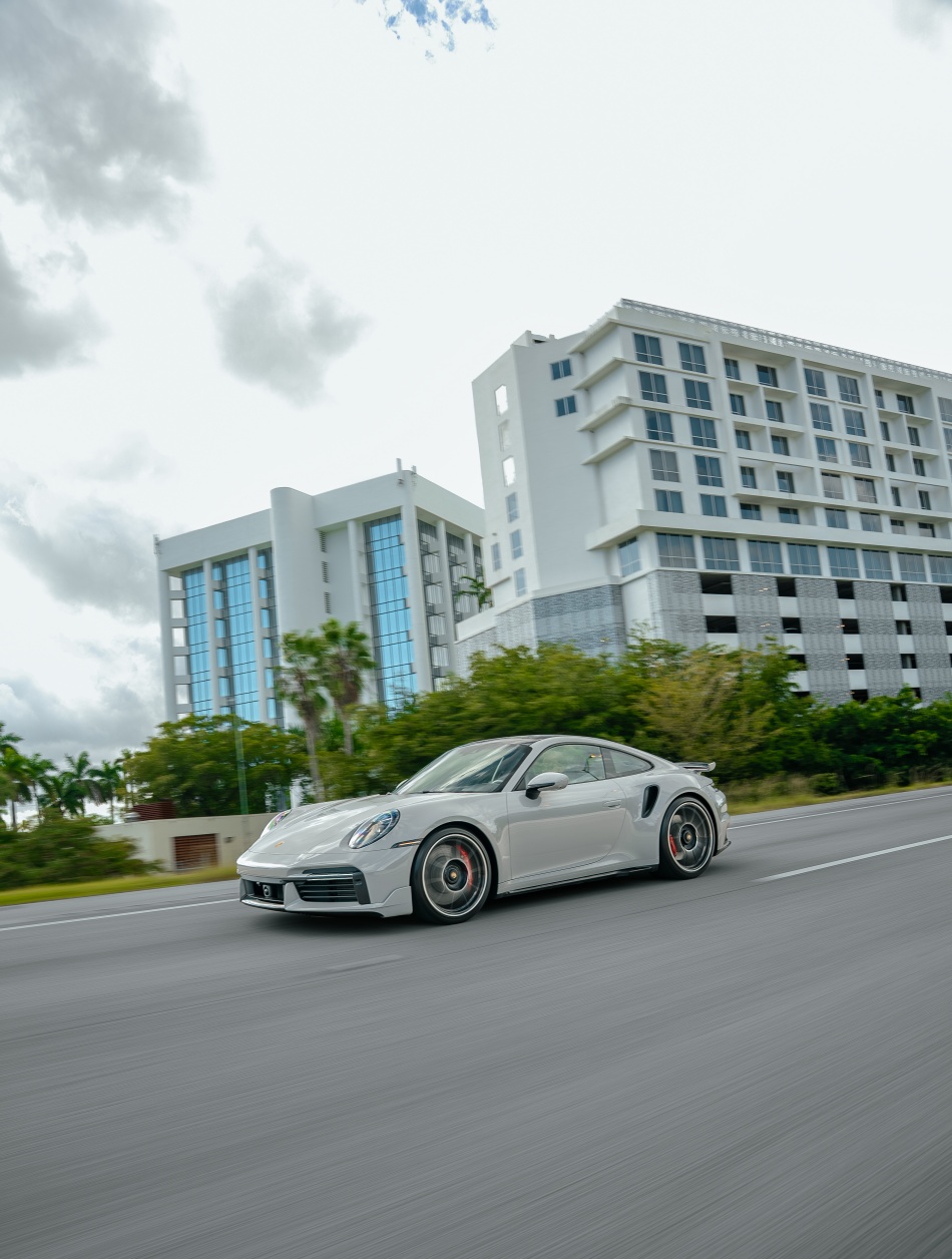 White Porsche 911 Turbo S in motion on Miami road