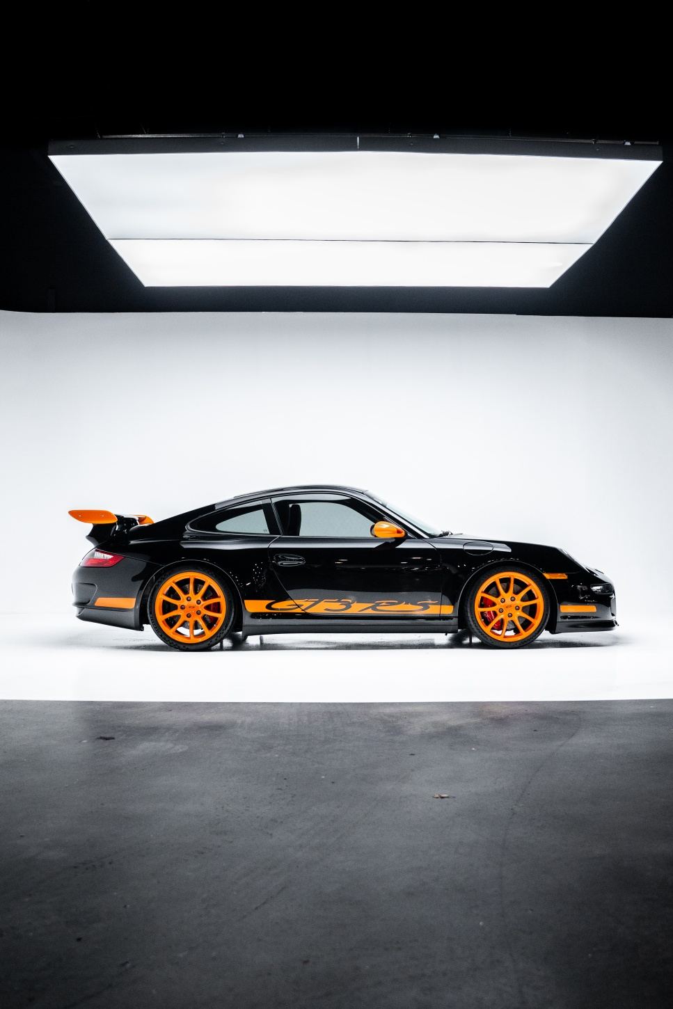 Black and orange Porsche 997 GT3 RS in studio