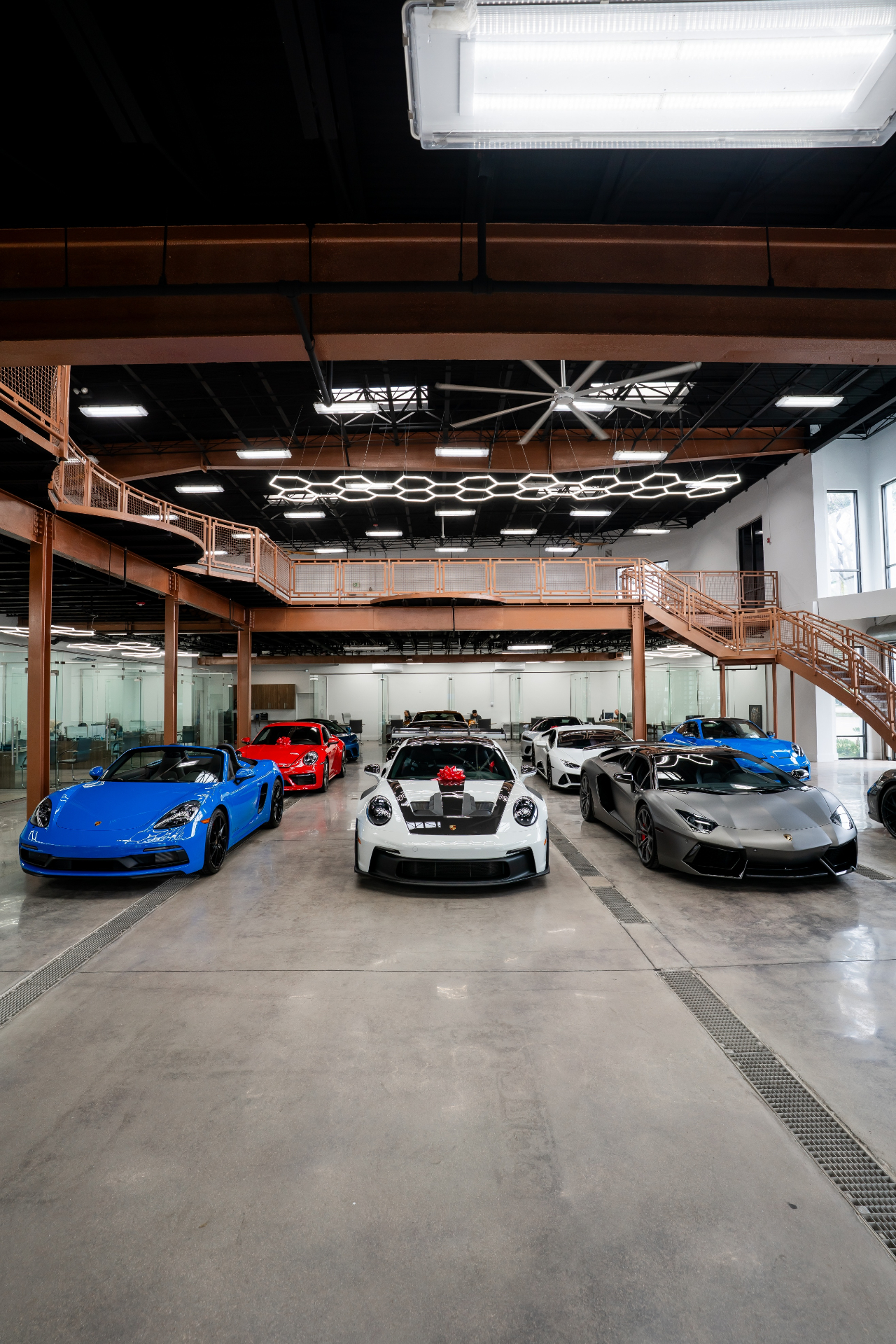 Showroom of exotic cars including Porsche and Lamborghini